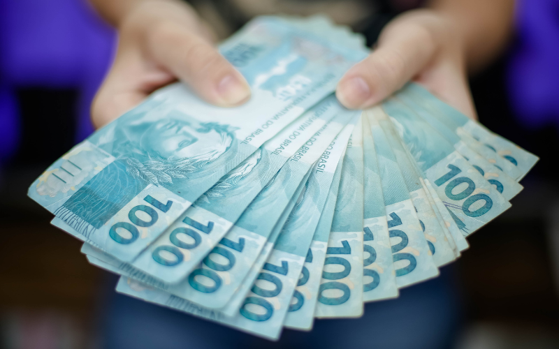Notas brasileiras de 100 reais indicando um empréstimo