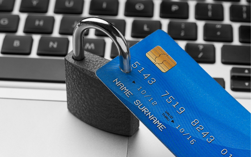 cadeado de bloqueio com cartão de crédito em cima do laptop simbolizando a proteção de um seguro de cartão de crédito